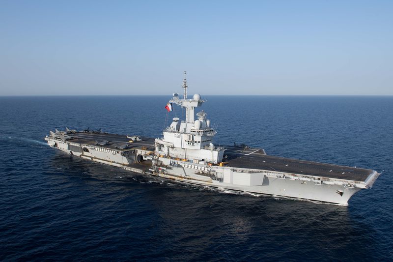 French aircraft carrier Charles de Gaulle (R91) underway at sea, showing the full flight deck with aircraft and the ship's island superstructure flying the French flag