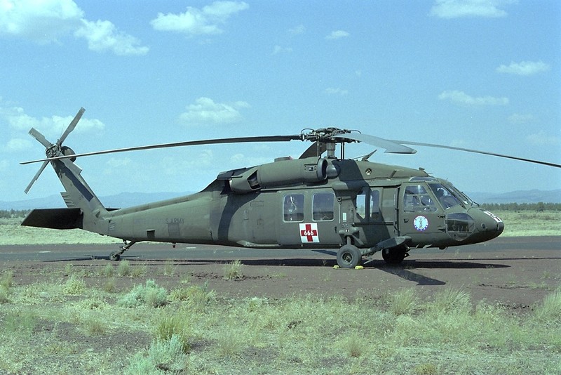 A UH-60 Black Hawk helicopter with red cross medical evacuation markings in flight
