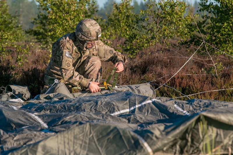 An 82nd Airborne Division paratrooper assembles equipment on a military base